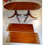 A mahogany twin pedestal dining table, the reeded edge 'D' ended rectangular top with two extra