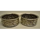 A pair of Garrard & Co Regency plate decanter stands, the sides with repousse foliage, grape vines