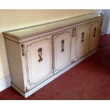 A painted side cabinet, with a mirror plateau top, having raised gilt gesso decoration, the cupboard