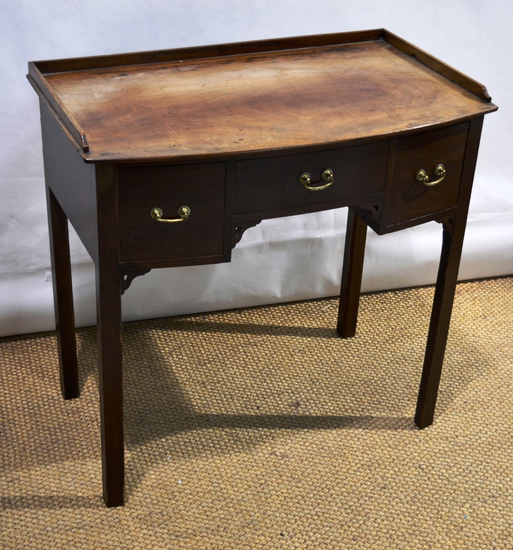 A late nineteenth century Sheraton Revival mahogany bow fronted dressing table, the top with a