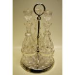 A late Victorian tantalus the electroplated circular frame with three glass diagonal cut decanters