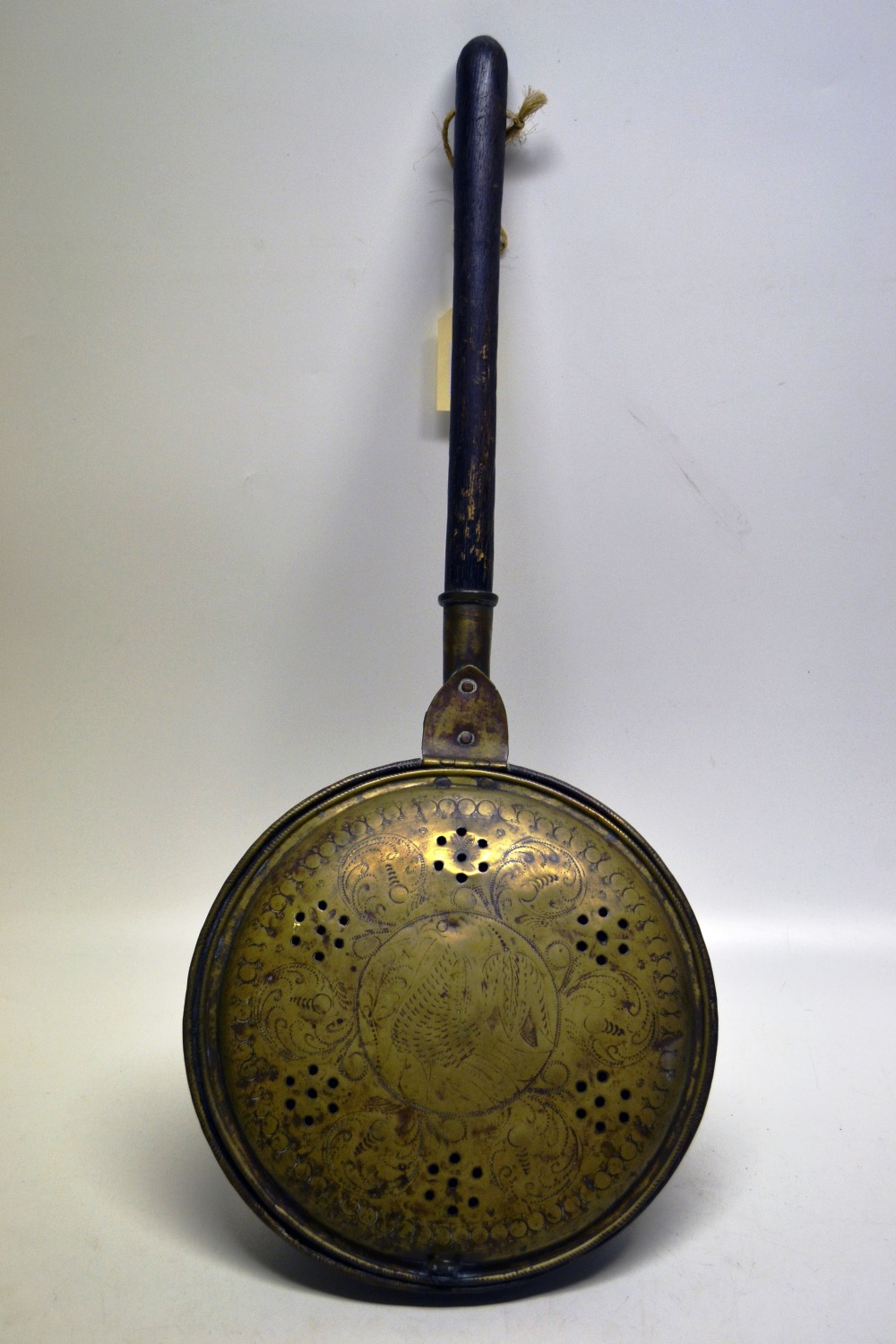 A William and Mary brass warming pan, the pierced hinged cover engraved a pheasant and a tulip,