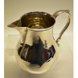 A silver baluster cream jug, with sparrow beak spout and capped scroll handle. Maker Richard Comyns,