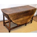 A large eighteenth century oak gateleg table, the oval drop leaf top fitted a frieze drawer each end