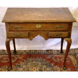 An eighteenth century oak lowboy, the moulded edge top above a long drawer with brass blind