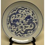 A large nineteenth century Chinese porcelain blue and white charger, decorated two dragons, each