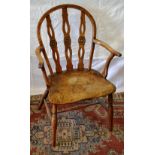 A yew back early nineteenth century Windsor elbow chair, the arched back with pierced and rondel