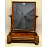 A William IV mahogany swing toilet mirror, the rectangular portrait glass on fluted scroll supports,