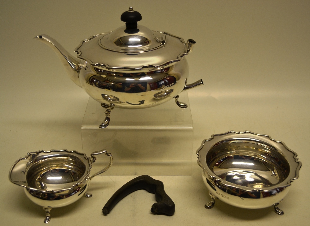 A George V silver compressed circular three piece tea service, with moulded borders, the teapot with