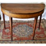 A Sheraton faded mahogany veneered elliptical card table, the fold over flap top lined with baize,