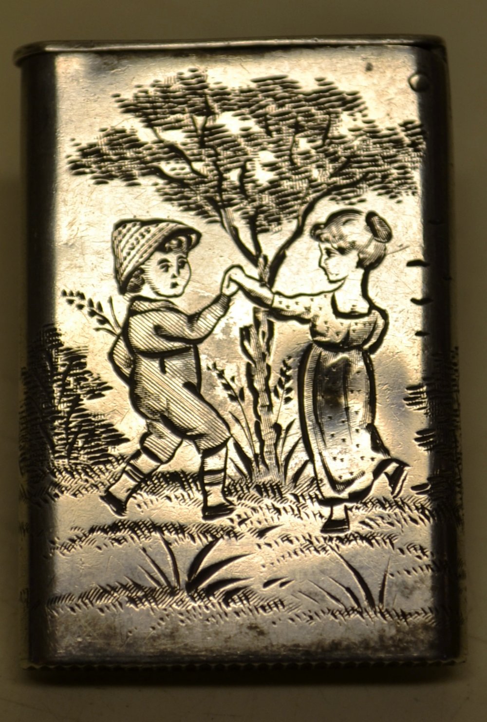 An unusual Victorian silver vesta case, engraved with children at play in the countryside, after