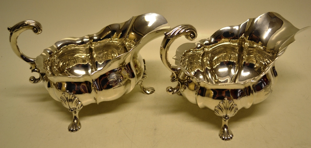 A large pair of early Victorian silver sauceboats, the everted panelled oval bodies engraved a