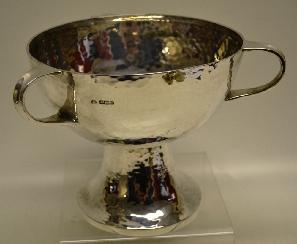 A George V silver hammered tyg, the bowl with 3 scroll handles on a pedestal circular foot. 6.