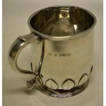 A child's silver mug, inscribed, with a capped scroll handle, a cut card petal collar, to he tuck in