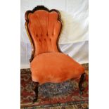 A Victorian occasional chair, the walnut shaped show frame back carved a spray of roses, button