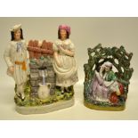 A Victorian Staffordshire group, of a young couple filling a pitcher with water from the head of a