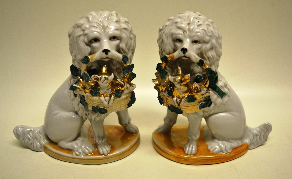 A pair of French porcelain late nineteenth century poodles, having a green ribbon to each neck and a