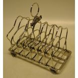 A Regency silver wirework six division toast rack, with shell and leaf scroll ring handle on shell