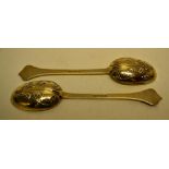 A pair of silver gilt lace back table spoons with mask foliage chased shaped terminals. Makers