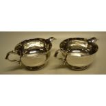 A pair of silver cream boats in West Country style, the hammered bodies with flared rims, cast