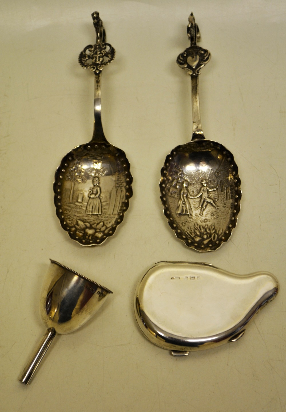 Two continental late nineteenth century silver spice spoons, decorated figures in old style dress,