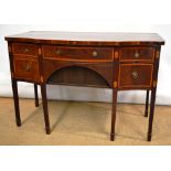 A Sheraton mahogany veneered serpentine front sideboard, inlaid stringing with oval shell marquetry,