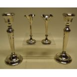 A pair of loaded silver candlesticks, Birmingham modern and a pair of small Edwardian silver