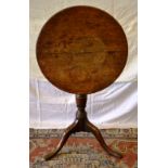A late eighteenth century oak occasional table, the circular tilt top on a vase turned stem, to
