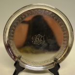 A George III silver circular salver, the centre engraved initials an engraved pendant border and