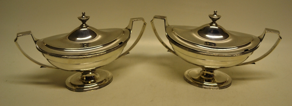 A pair of George III silver oval sauce tureens, with bracket loop handles and reeded borders, the