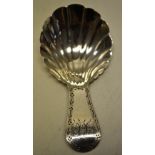 A George III silver caddy spoon, with a shell fluted bowl, the engraved border handle with initials.