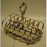 A Victorian silver toast rack, the six divisions with a central foliage ring handle, the scrolling