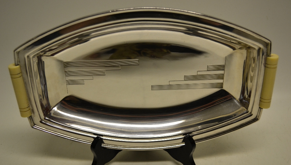 An art Deco electroplated Sheffield made ovoid bread dish, with engraved stepped bands and two ivory