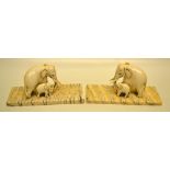 A pair of nineteenth century Indian ivory carved elephants with baby elephants, standing on