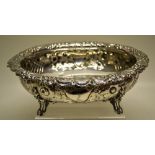 A late Victorian oval silver dessert bowl, the ogee sides with repoussé flowers and hatching,