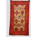 Good and very decorative yellow ground ikat silk panel within a red floral and boteh cotton border