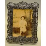 A Victorian pierced cast silver photograph frame, decorated foliage with circular open panels of