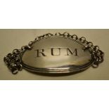 A George III silver oval RUM label with a reeded edge and a chain. Maker Thomas Phipps, Birmingham