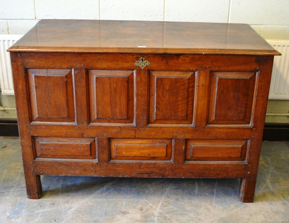 An eighteenth century North country oak blanket chest with panelled front and sides, a pierced brass