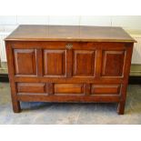 An eighteenth century North country oak blanket chest with panelled front and sides, a pierced brass