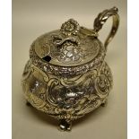 A large Regency silver mustard pot, the ogee body chased with repouse foliage scrolls and engraved