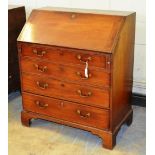 A George III mahogany bureau, the fall flap reveals a fitted interior with a serpentine edge
