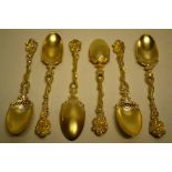 An unusual set of six Victorian parcel gilt silver teaspoons, the open tendril stem handles with