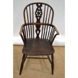 A nineteenth century beech Windsor armchair, with a wheel back splat, the elm seat with old