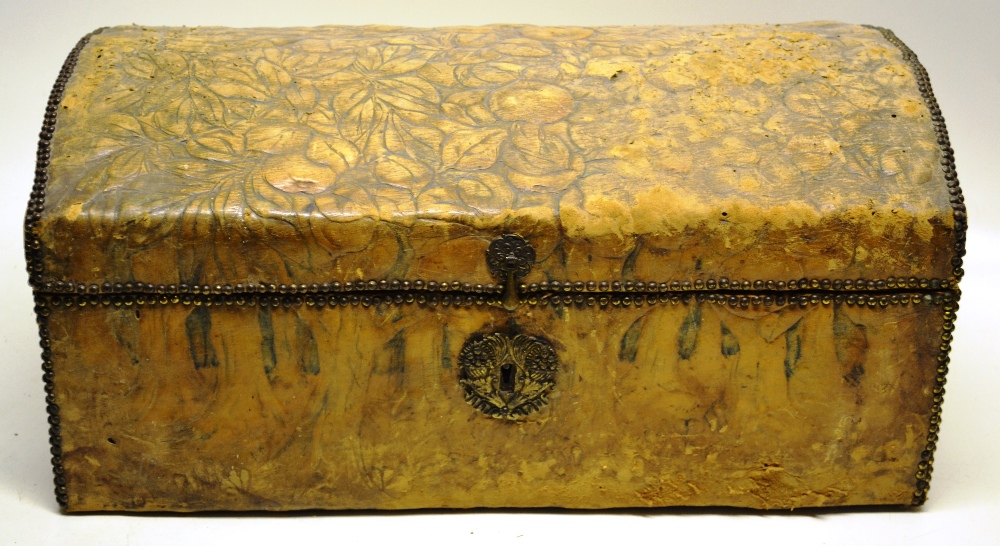 A small antique travelling trunk, covered in embossed leather fruit and foliage with brass nailed