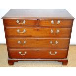 A George III mahogany chest of two short and three long graduated oak lined drawers, with later