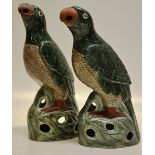 A pair of Chinese Republic famile verte porcelain parrots, perched on open rocky bases, circa