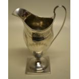 A George III silver vase shape cream jug, with engraved decoration and a vacant cartouche, a fine
