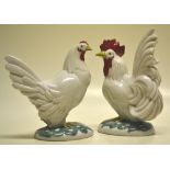 A mid twentieth century oriental porcelain cockerel and a hen, on oval green foliage decorated