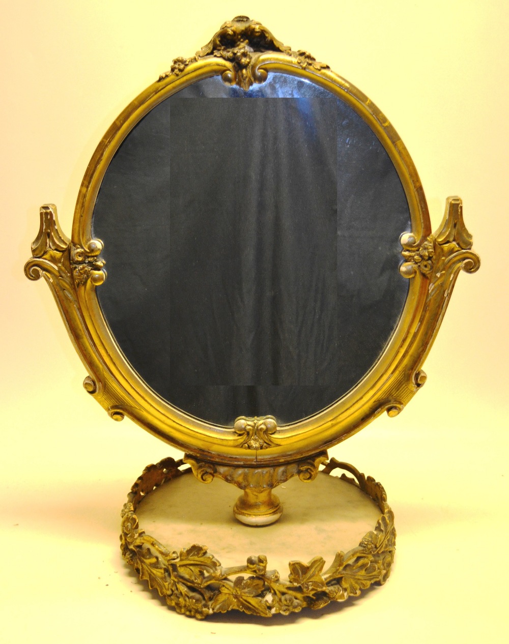 A Franglais nineteenth century gilt frame oval toilet mirror, the scrolling frame with sprays of
